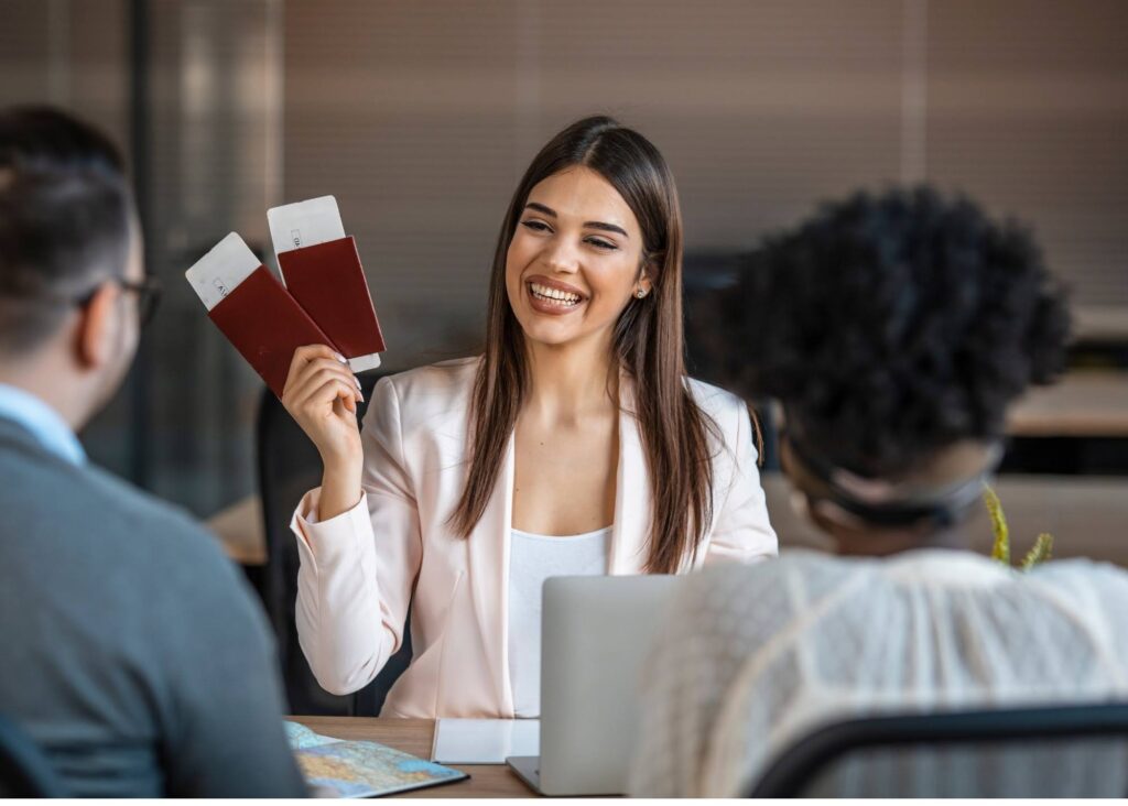 A travel agent holding up two travel tickets