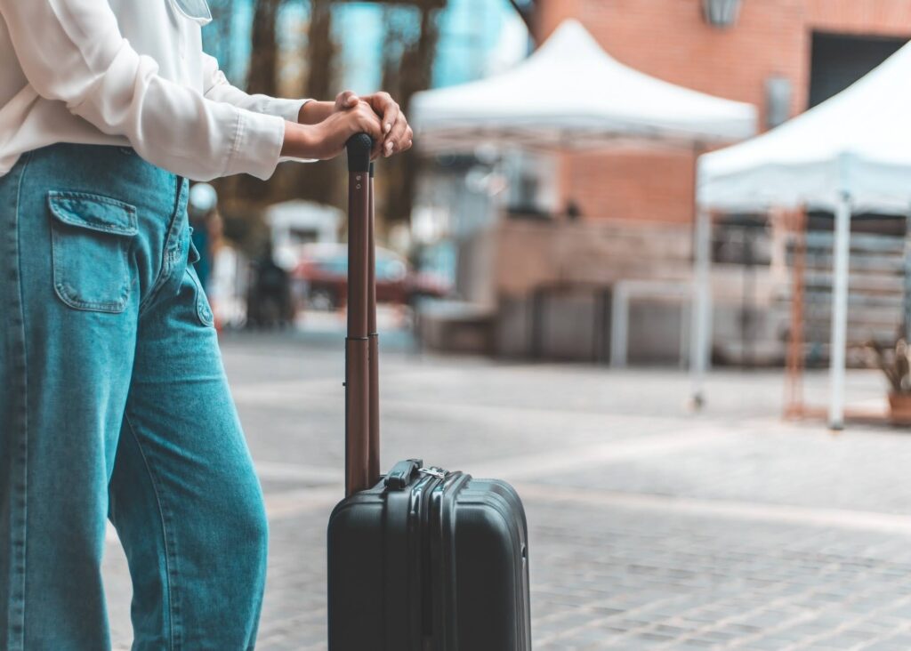 A person waiting with their suitcase